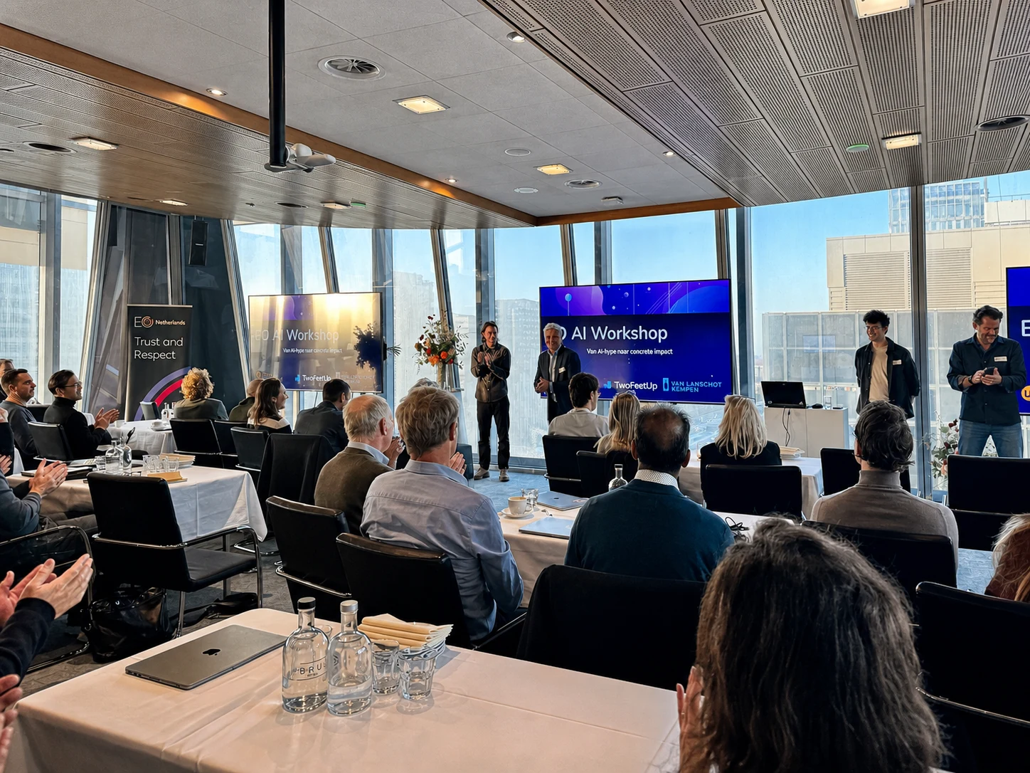 Deelnemers applaudisseren aan het einde van de EO AI Workshop.